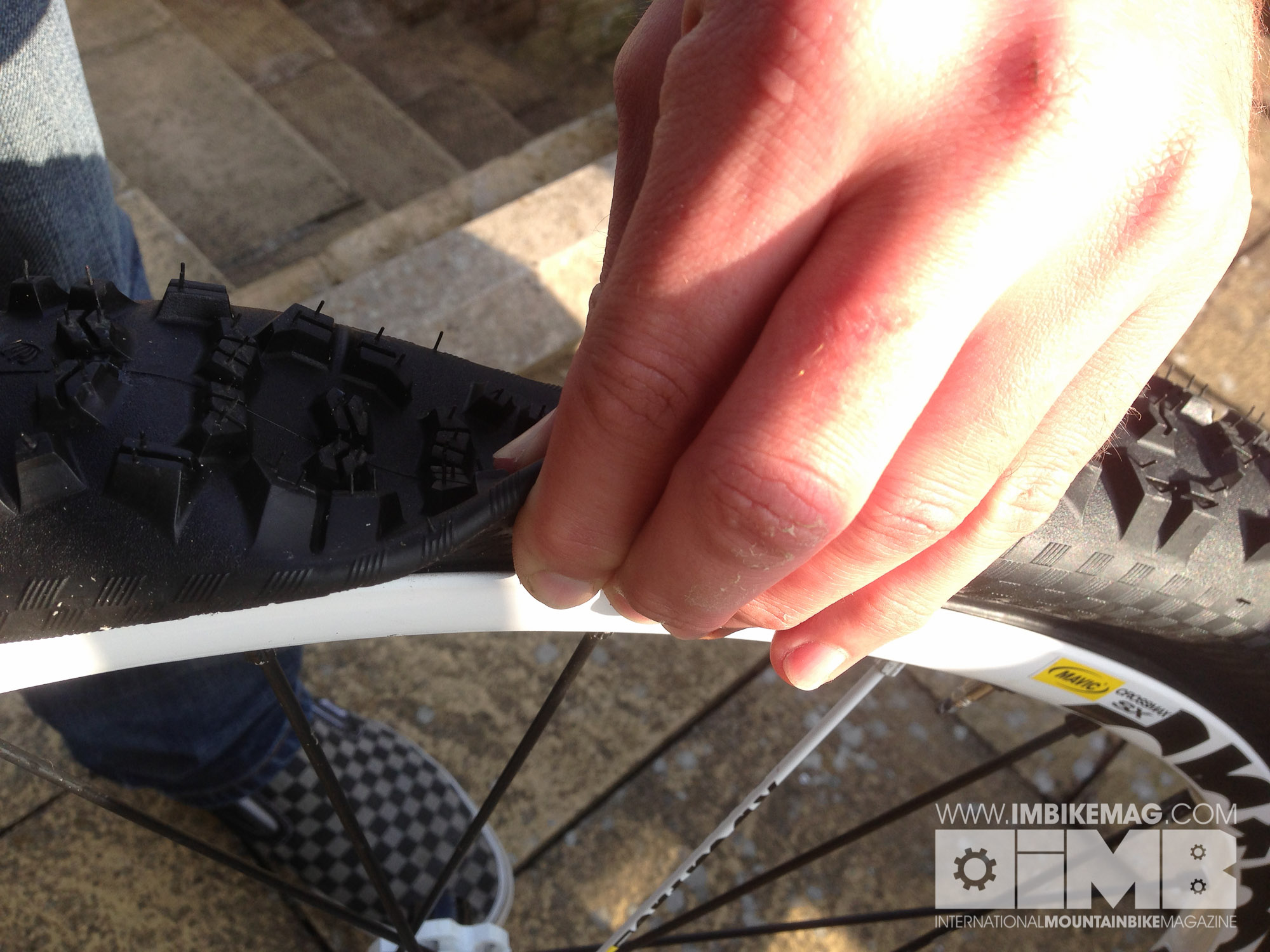 Pinch the side of the tyre and pull the bead onto the rim.